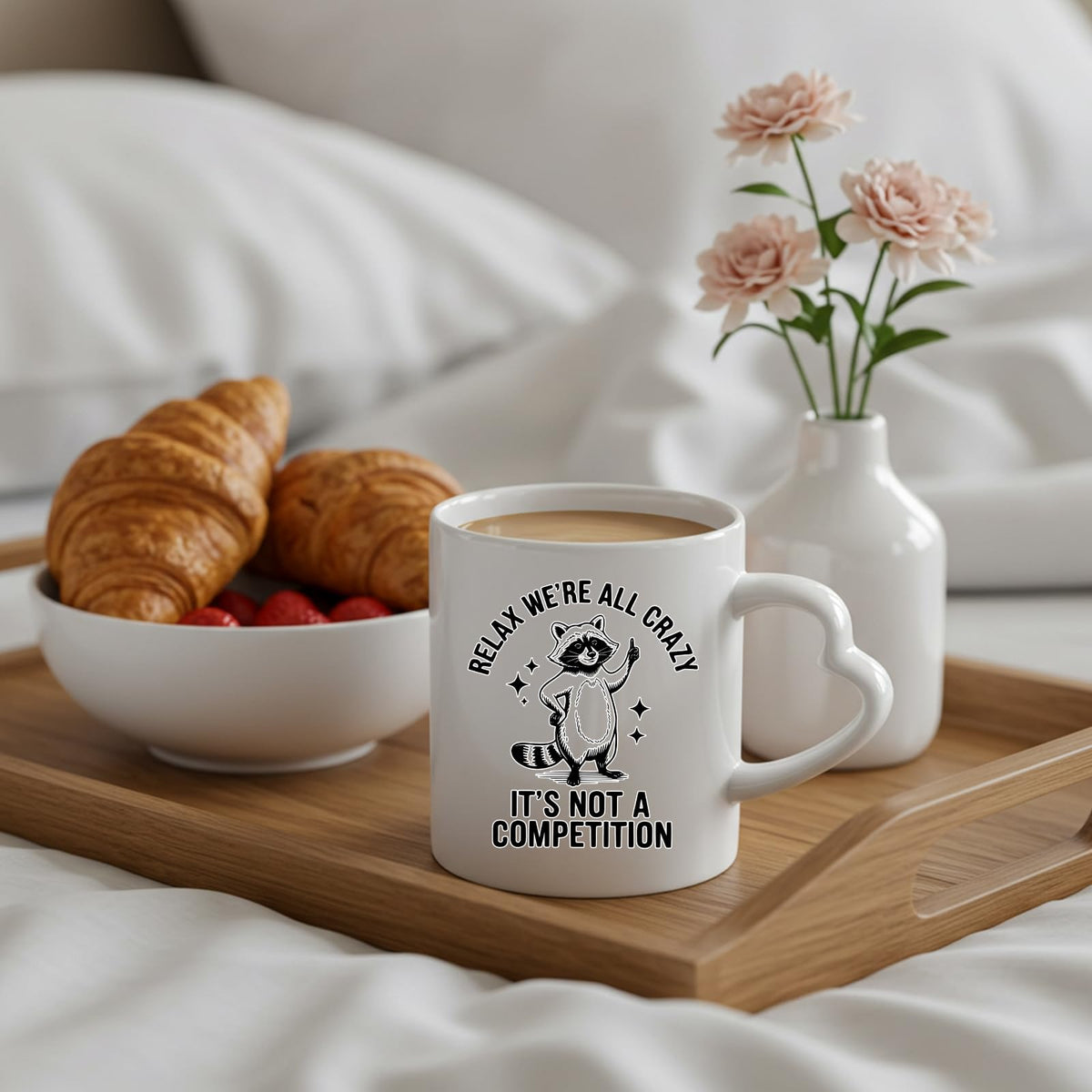 Relax We’re All Crazy raccoon heart-handle mug on a breakfast tray with croissants and flowers