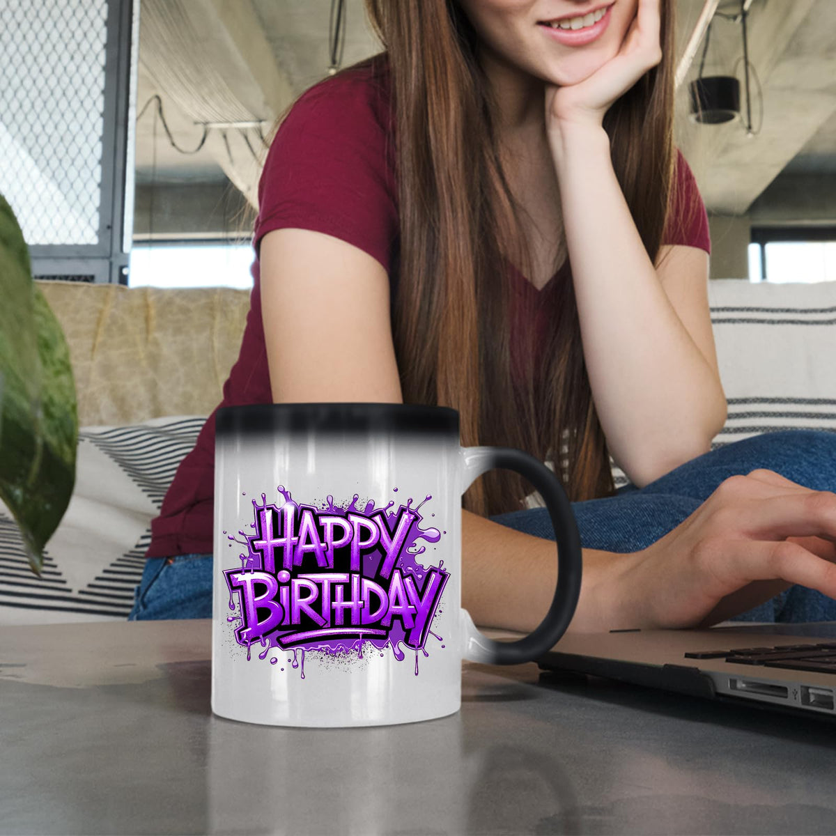 Woman at a laptop with the Happy Birthday purple graffiti colour changing mug