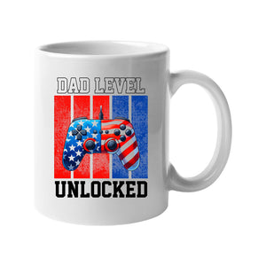 White mug with a stars-and-stripes game controller and “Dad level unlocked”