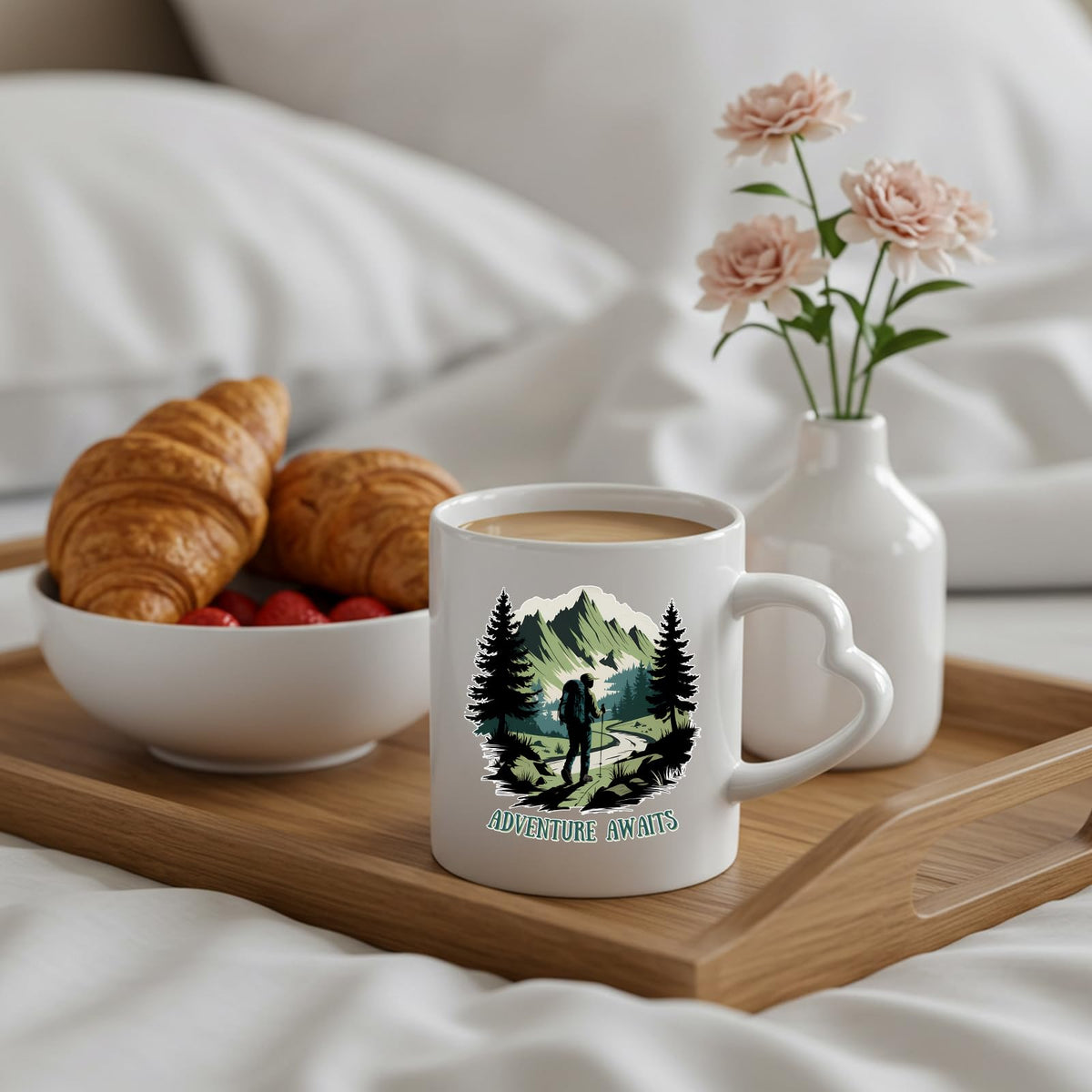 Adventure Awaits hiker heart-handle mug on a breakfast tray with croissants and flowers