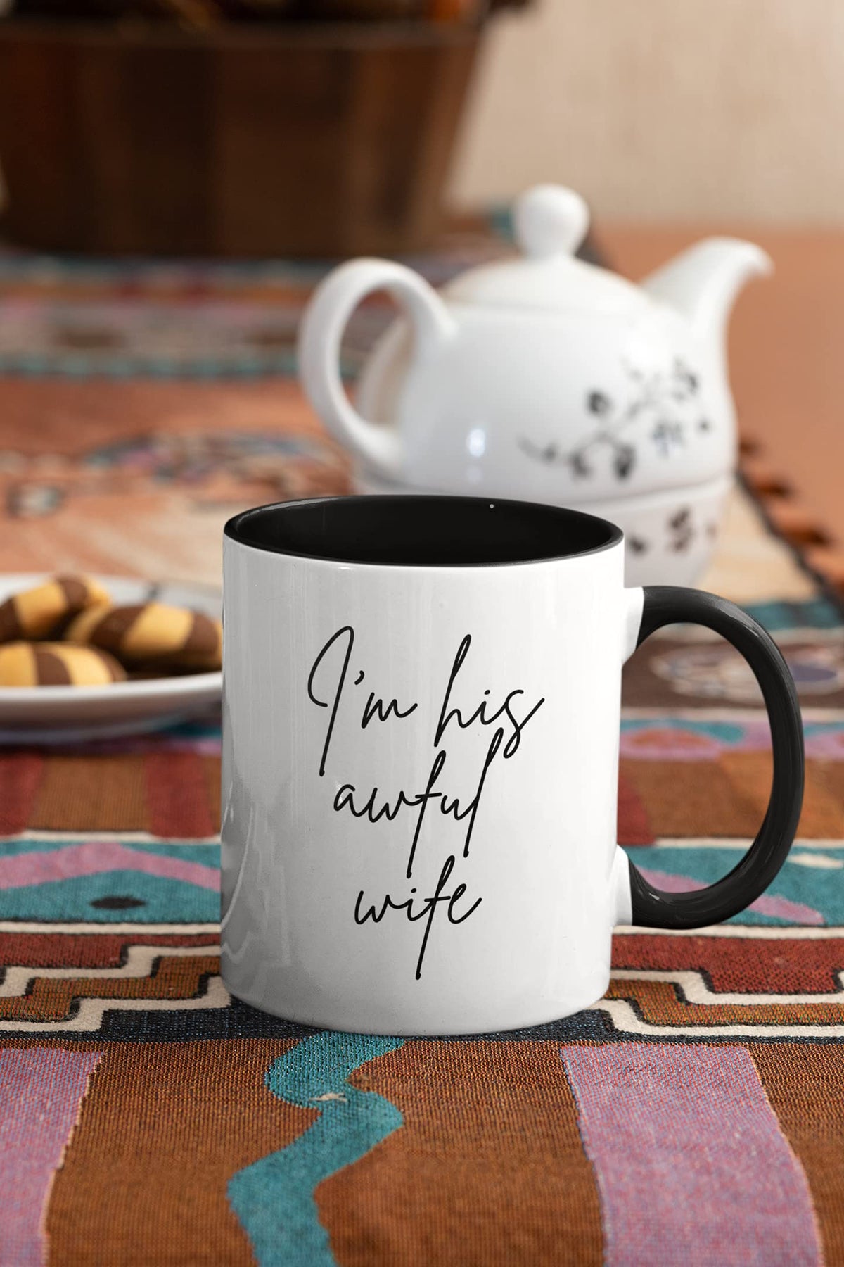 Awful wife mug next to a teapot and biscuits