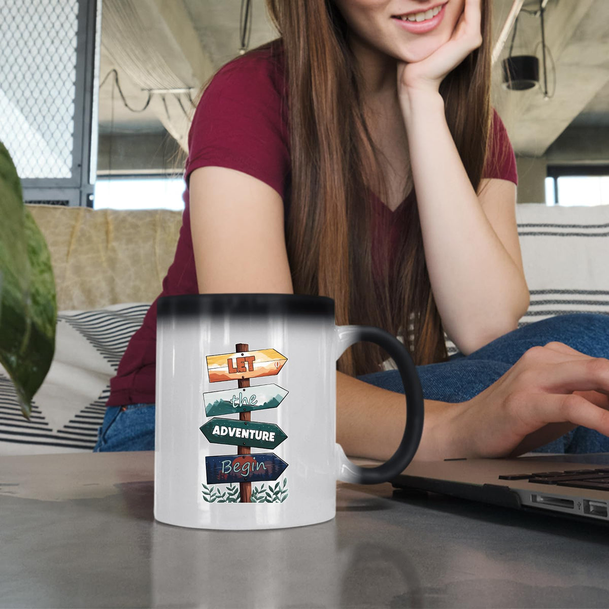 Woman at a laptop with the Let the Adventure Begin colour changing mug