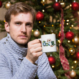 Man holding the Reel Cool Dad mug in front of a Christmas tree