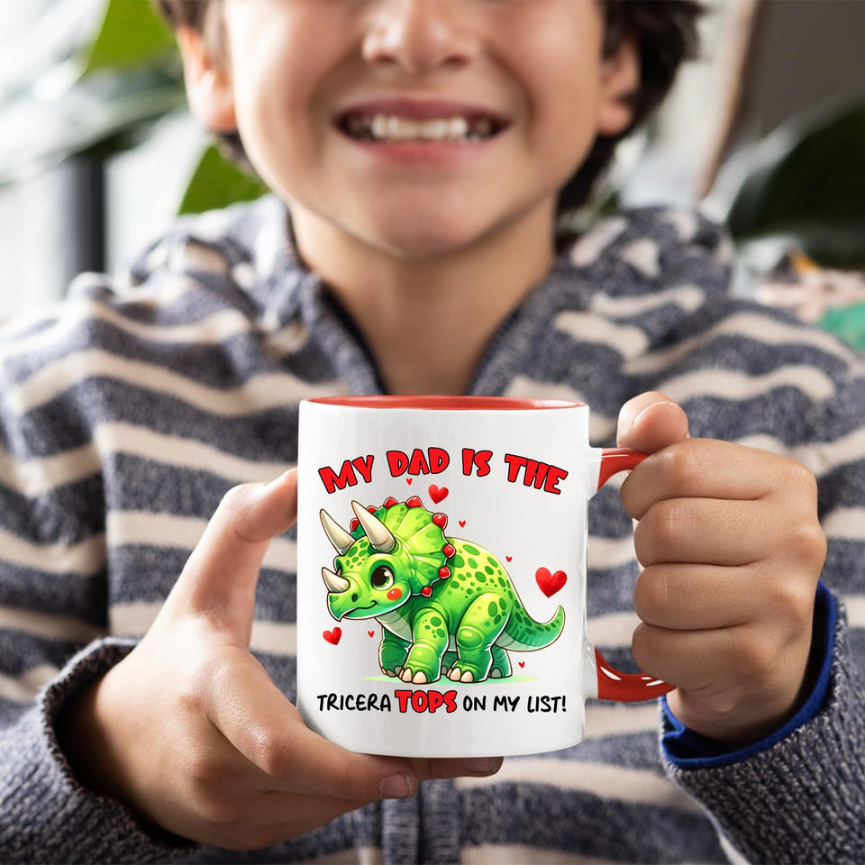 Smiling child holding the Triceratops dad mug with a red handle