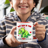 Smiling child holding the Triceratops dad mug with a red handle