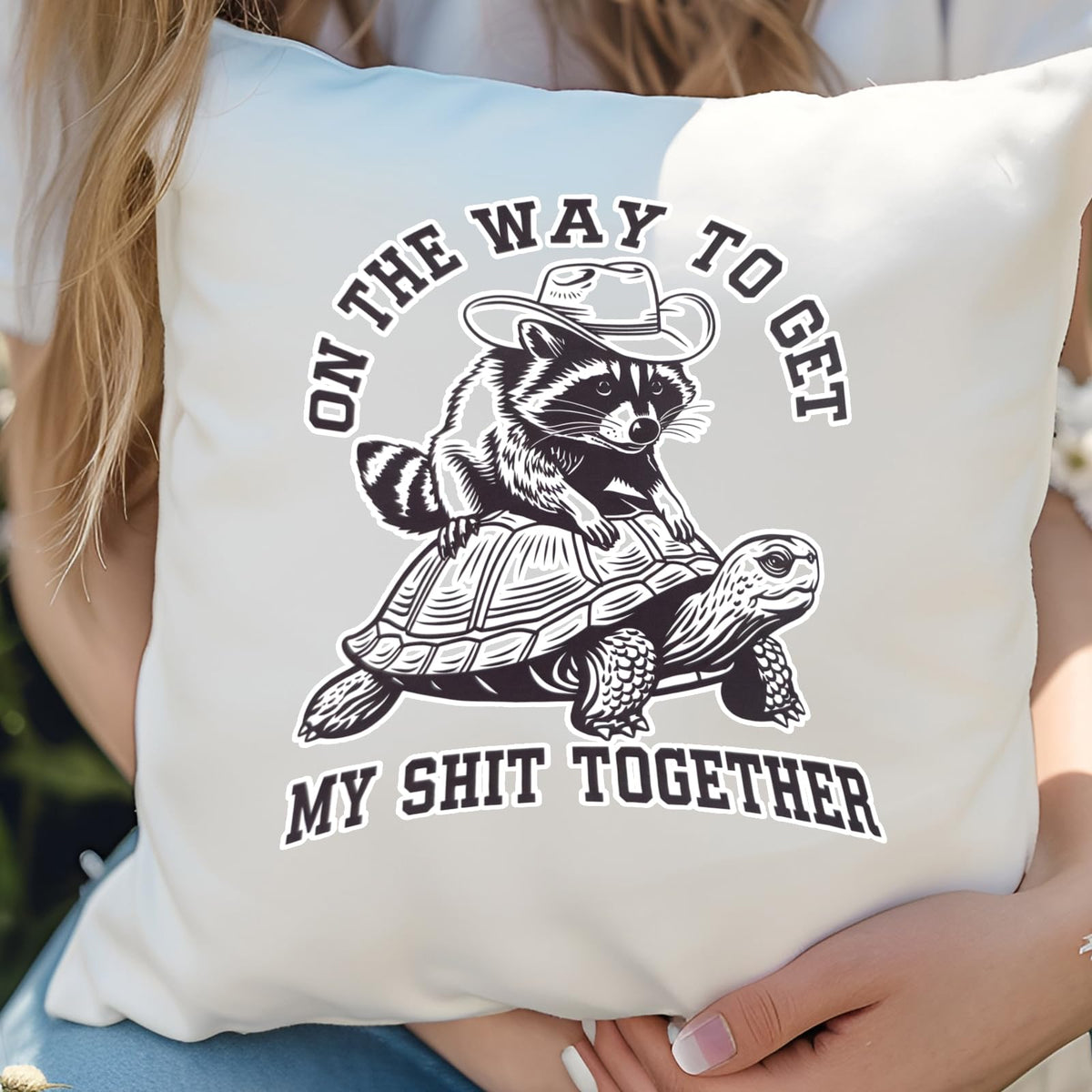 Hands holding the raccoon and tortoise cushion