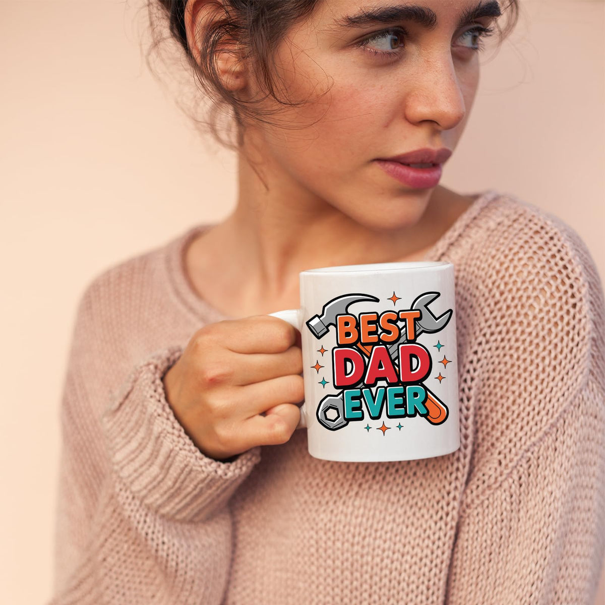 Woman in a pink jumper holding the Best Dad Ever tools mug