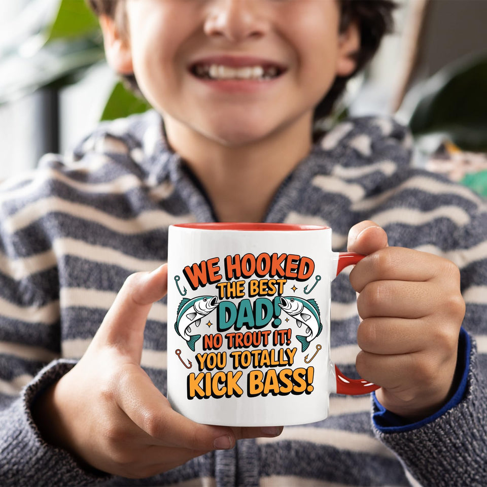 Smiling child holding the We Hooked the Best Dad mug with a red handle