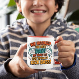 Smiling child holding the We Hooked the Best Dad mug with a red handle