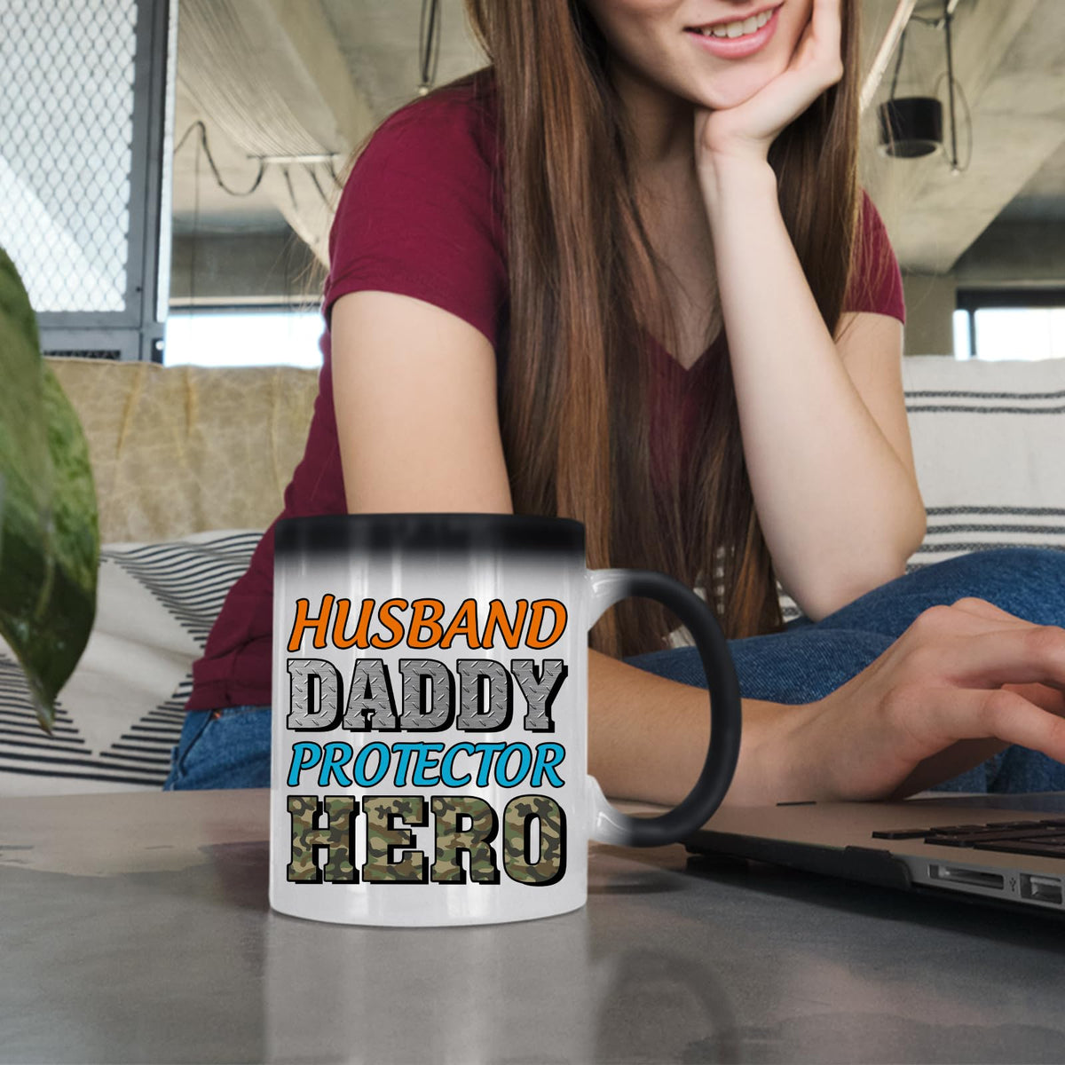 Woman at a laptop with the Husband Daddy Protector Hero camo colour changing mug