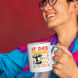 Smiling person in a colourful jacket holding the If Dad Can’t Fix It mug with a light green handle