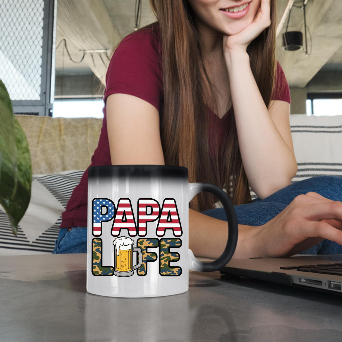 Woman at a laptop with the Papa Life colour changing mug