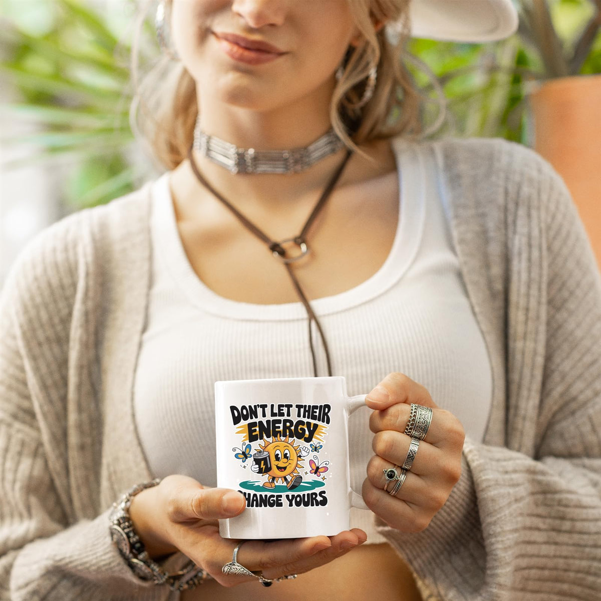 Woman in a cardigan holding the Positive Vibes sun mug