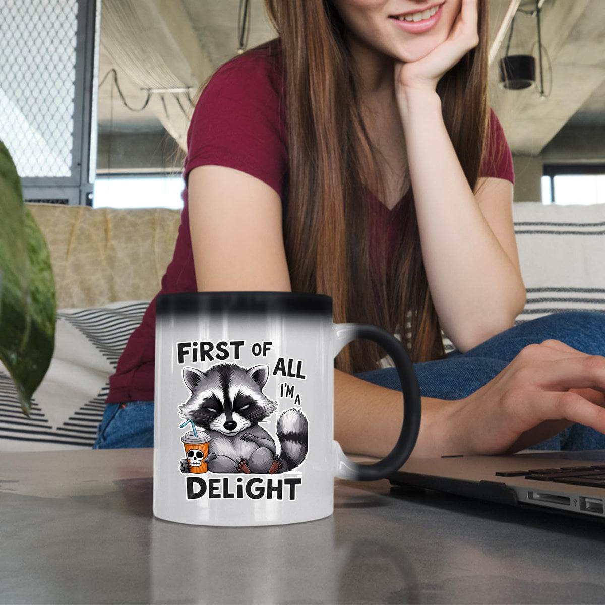Woman at a laptop with the First of All I’m a Delight raccoon colour changing mug