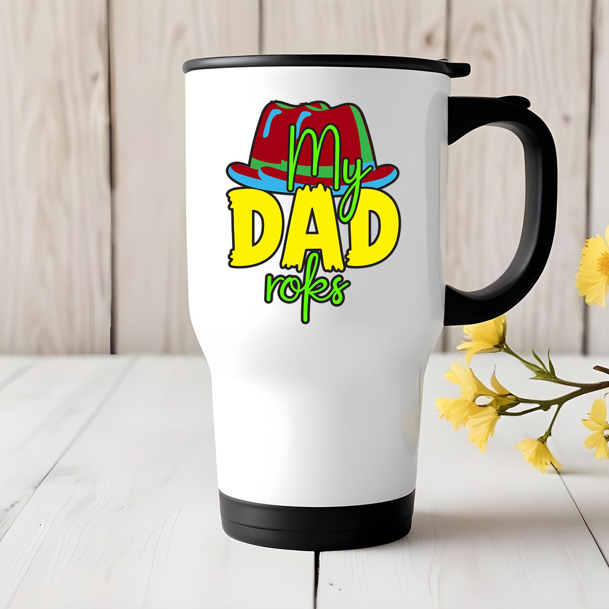 Travel mug with the My Dad Rocks design on a white table with yellow flowers