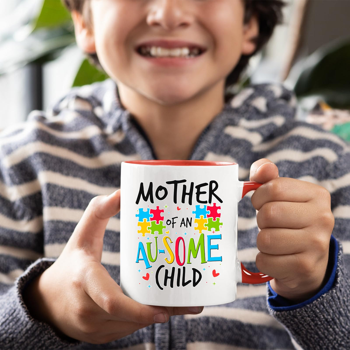 Smiling child holding the Mother of an Au-Some Child mug with a red handle
