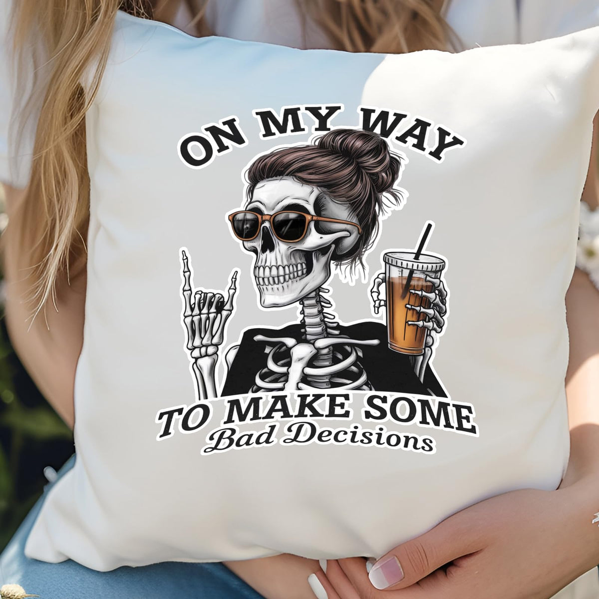 Hands holding the Bad Decisions skeleton cushion