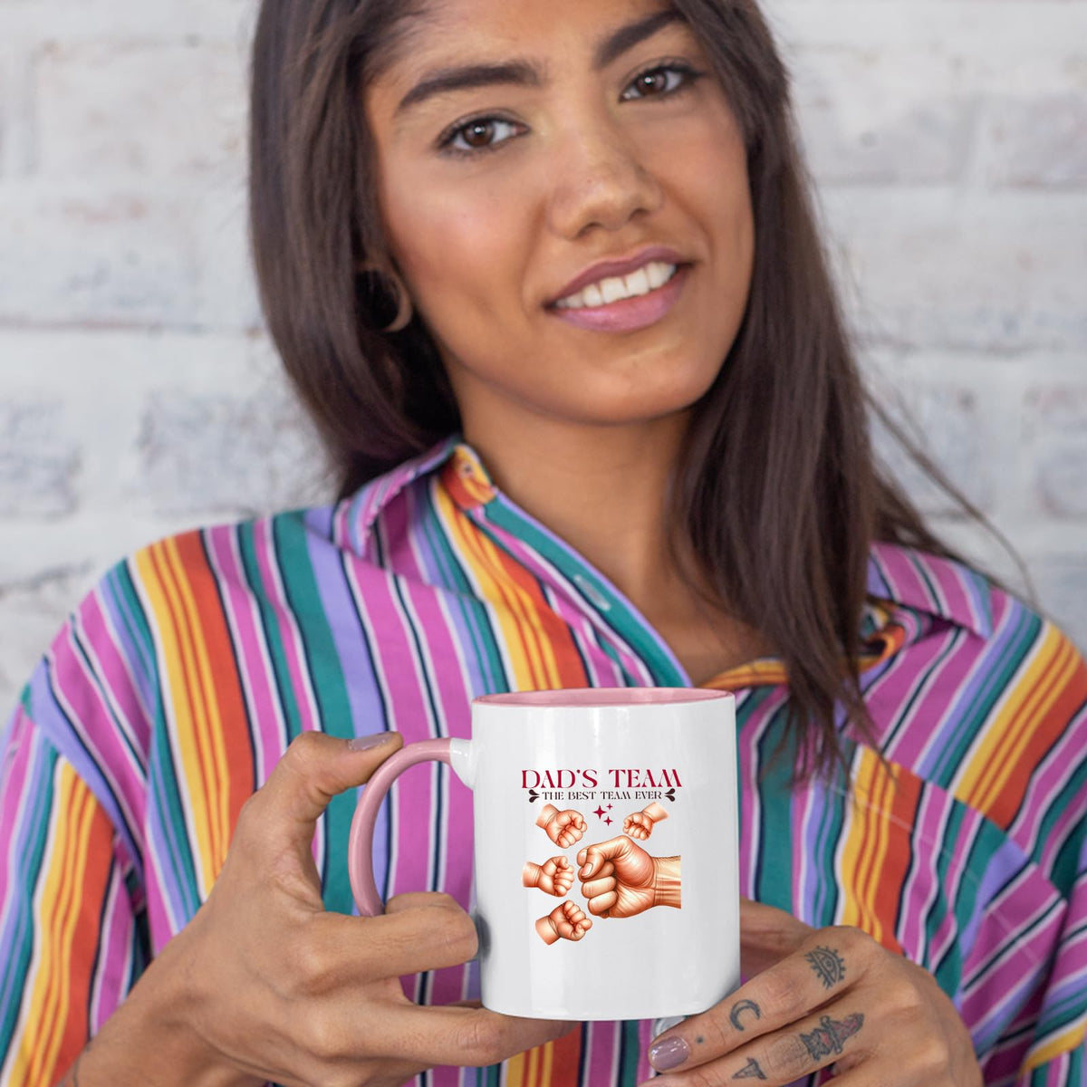 Woman in a striped shirt holding the Dad’s Team fist bump colour handle mug