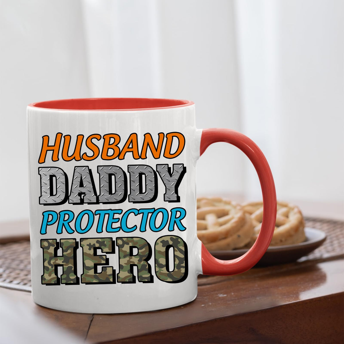 Husband Daddy Protector Hero camo mug with a red handle beside biscuits