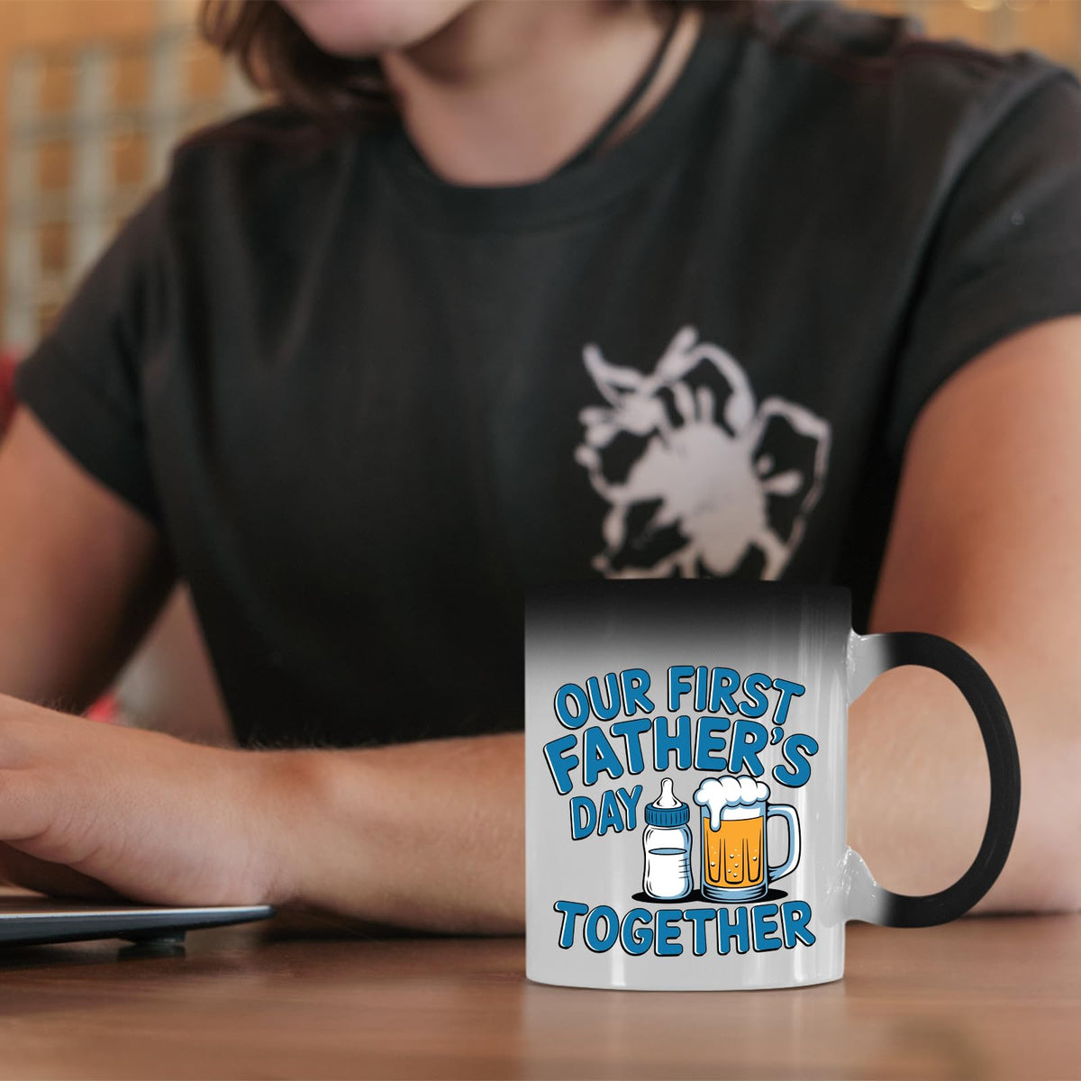 First Father’s Day bottle and beer colour changing mug on a desk beside a laptop