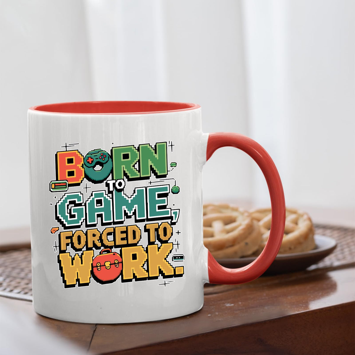 Born to Game mug with a red handle beside biscuits