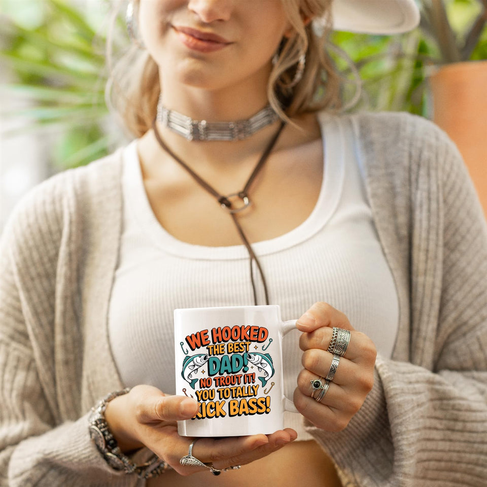 Woman in a cardigan holding the We Hooked the Best Dad mug