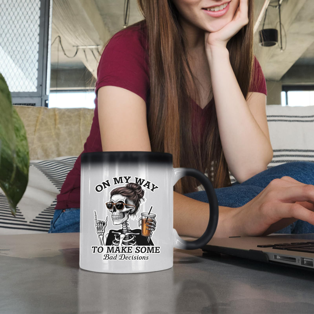 Woman at a laptop with the Bad Decisions skeleton colour changing mug
