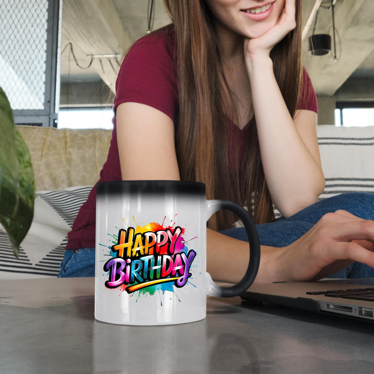 Woman at a laptop with the Happy Birthday rainbow splash colour changing mug