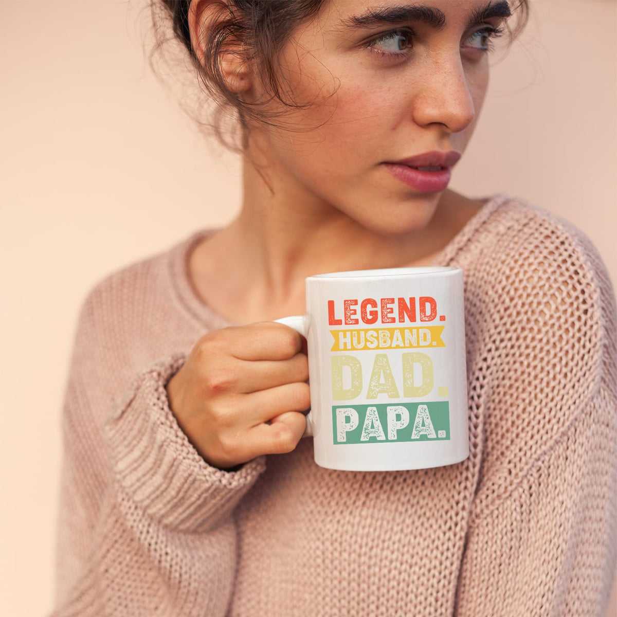 Woman in a pink jumper holding the Legend Husband Dad Papa mug