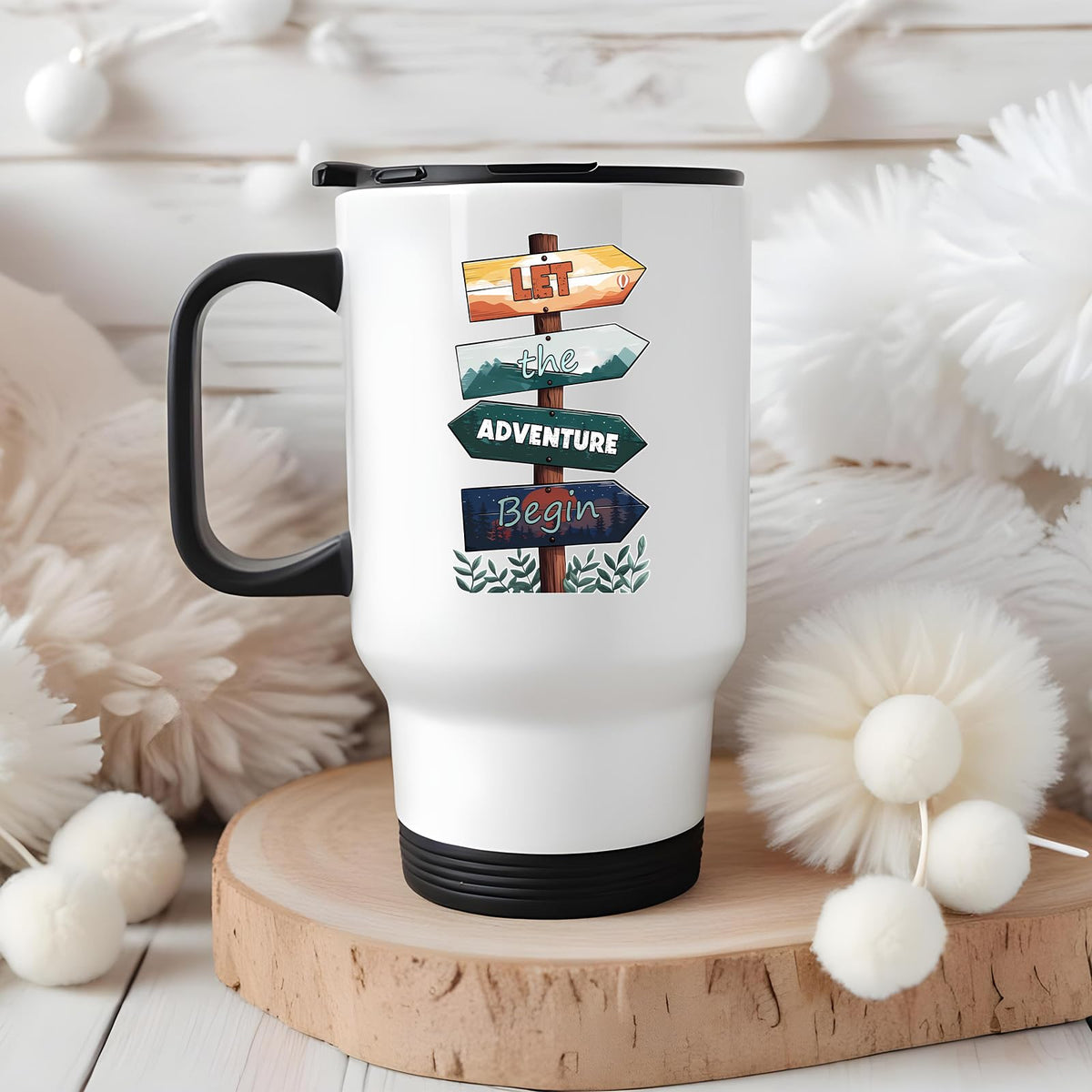 Let the Adventure Begin travel mug on a wooden slice with white pom-poms