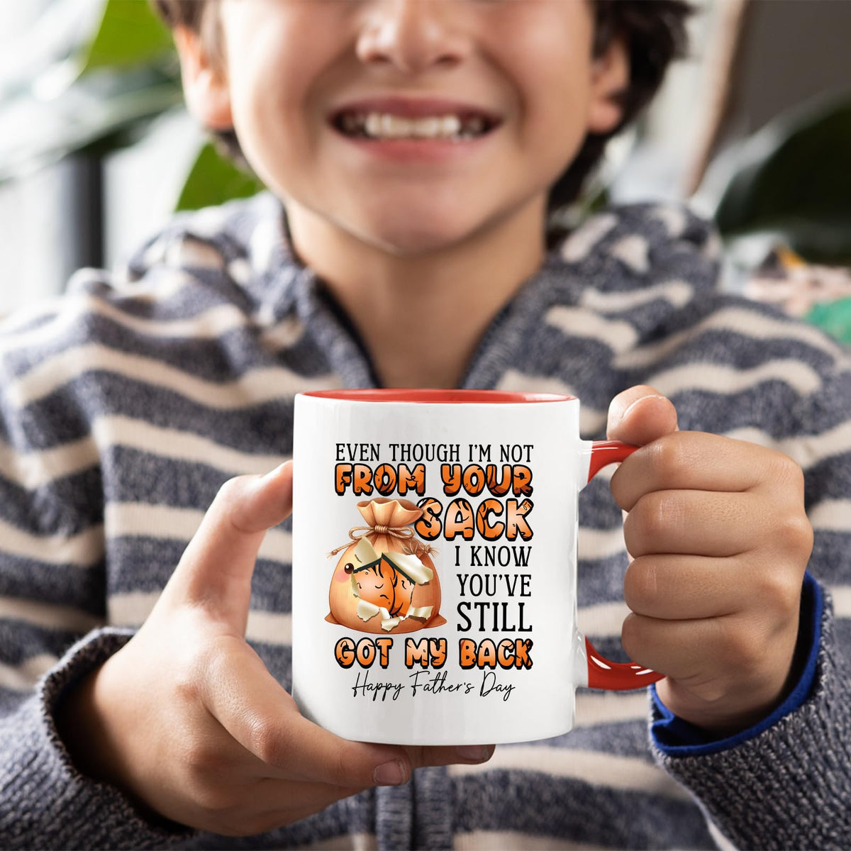 Smiling child holding the Not From Your Sack mug with a red handle