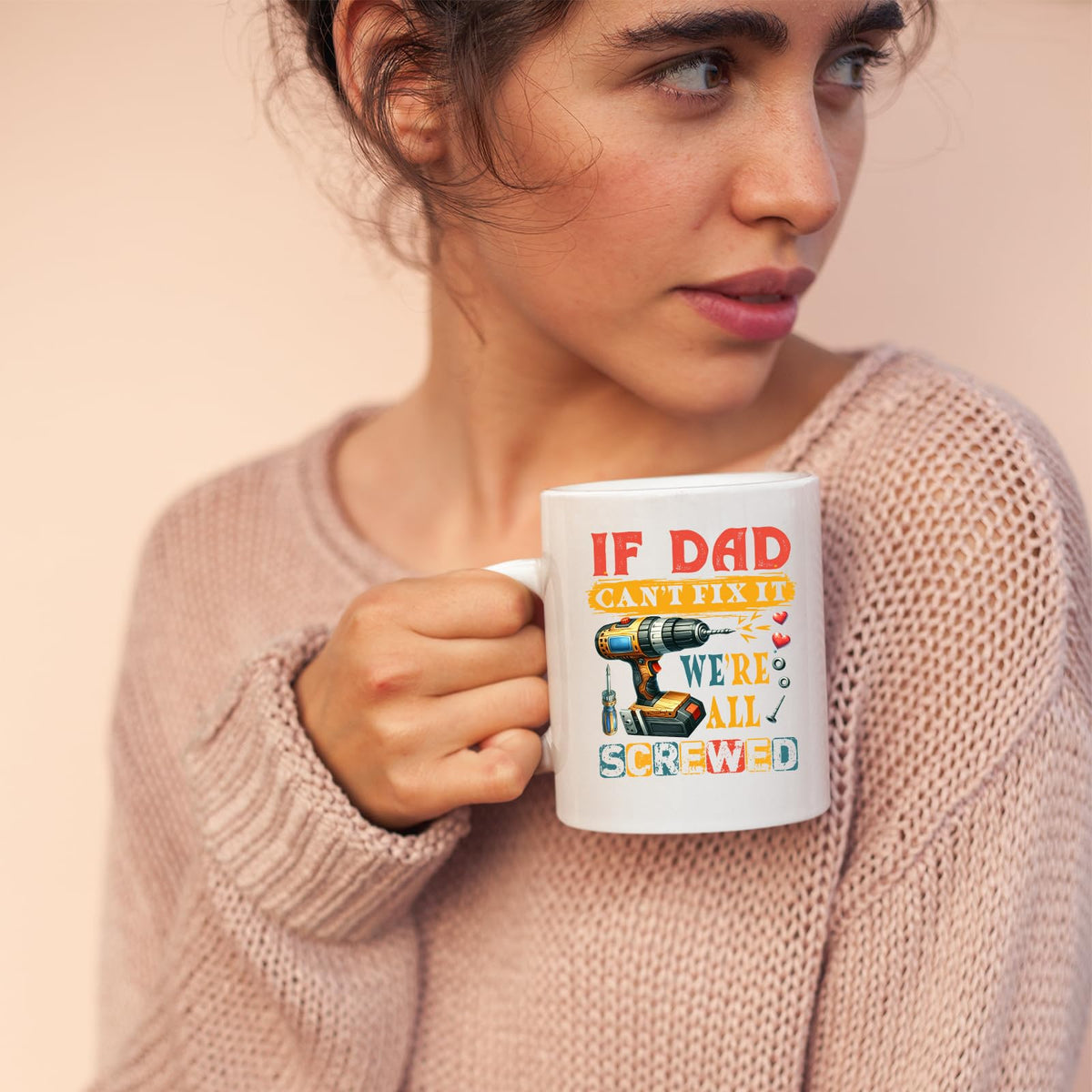 Woman in a pink jumper holding the If Dad Can’t Fix It mug