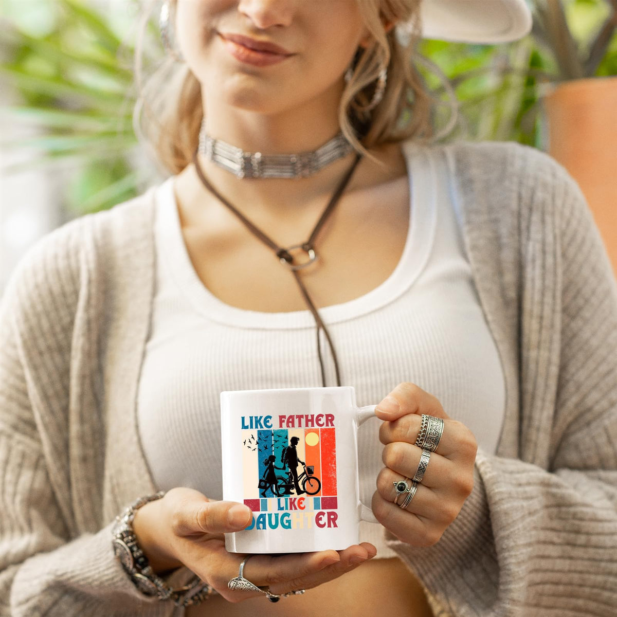 Woman in a cardigan holding the Like Father Like Daughter mug
