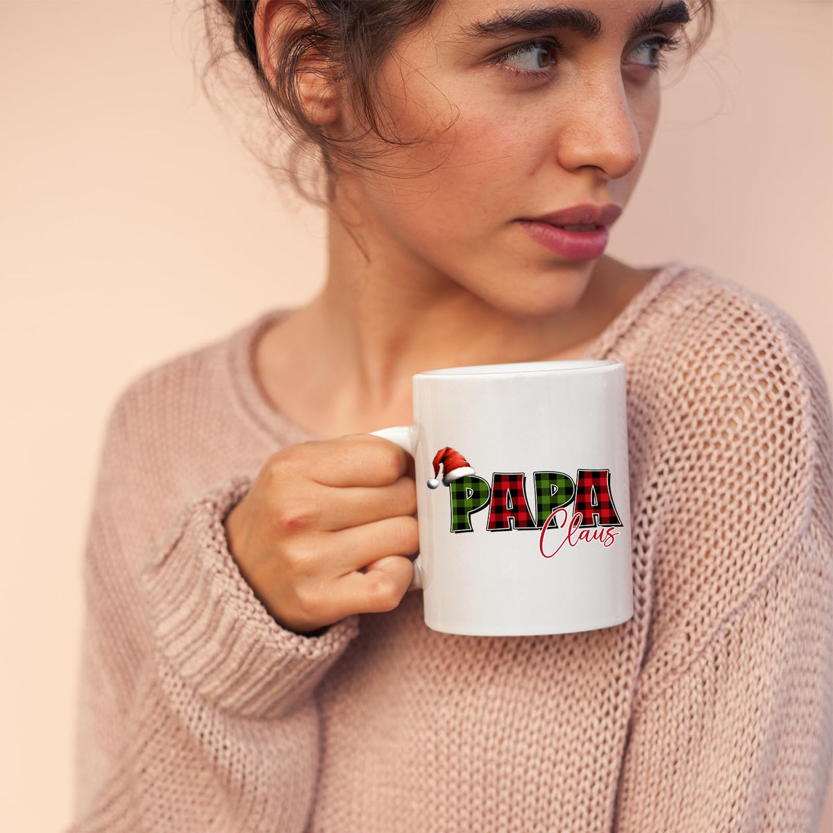 Woman in a pink jumper holding the Papa Claus mug