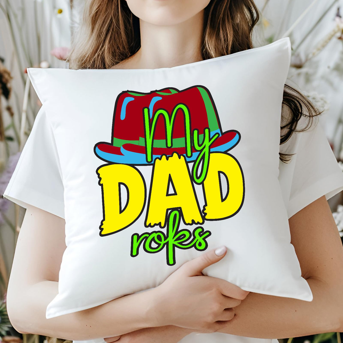 Woman holding a cushion with the colourful My Dad Rocks hat design
