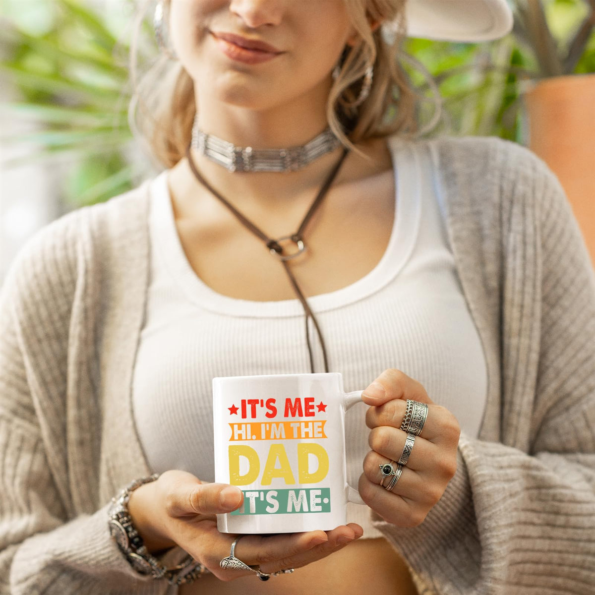 Woman in a cardigan holding the It’s Me Hi I’m the Dad mug