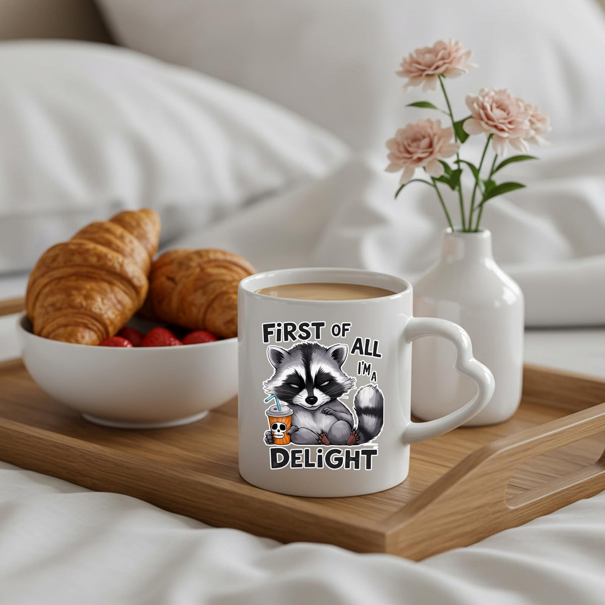 First of All I’m a Delight raccoon heart-handle mug on a breakfast tray with croissants and flowers