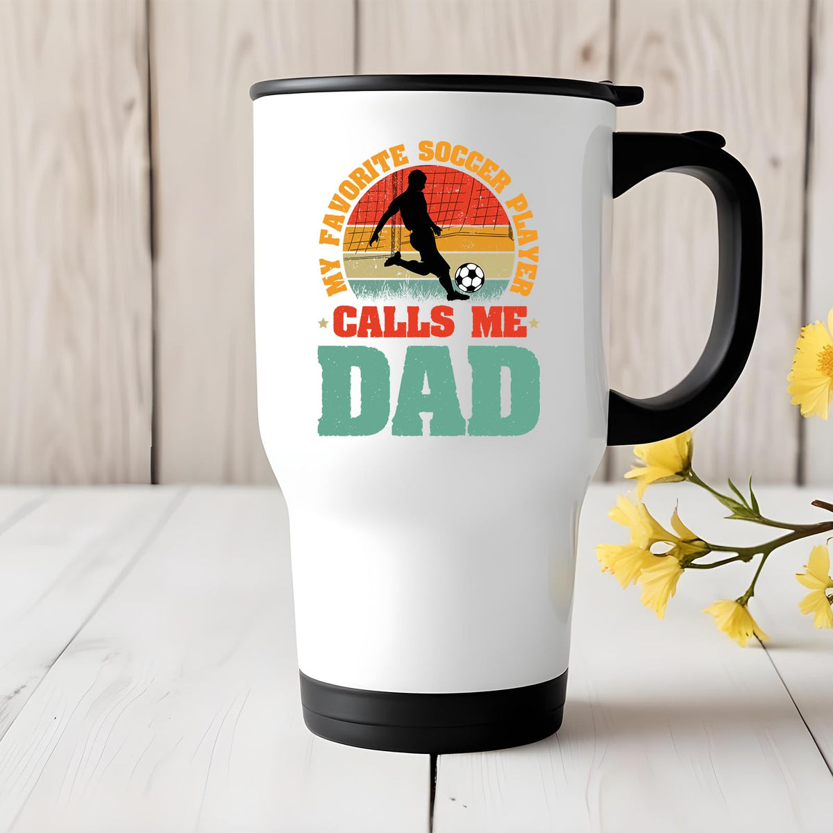 Soccer Dad travel mug on a white wooden table with yellow flowers