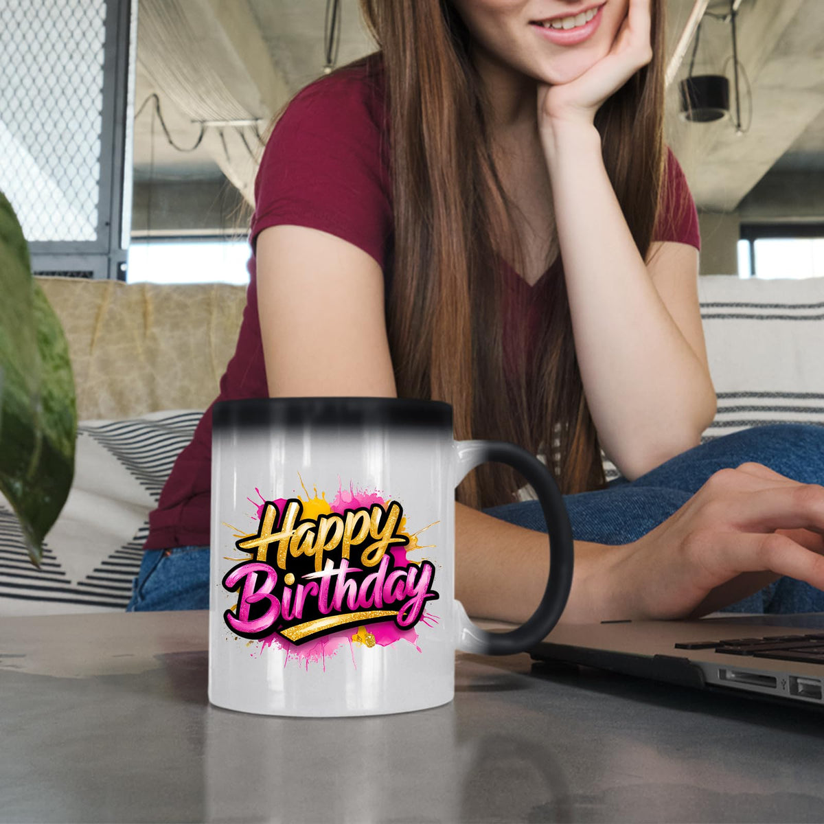 Woman at a laptop with the Happy Birthday gold and pink colour changing mug
