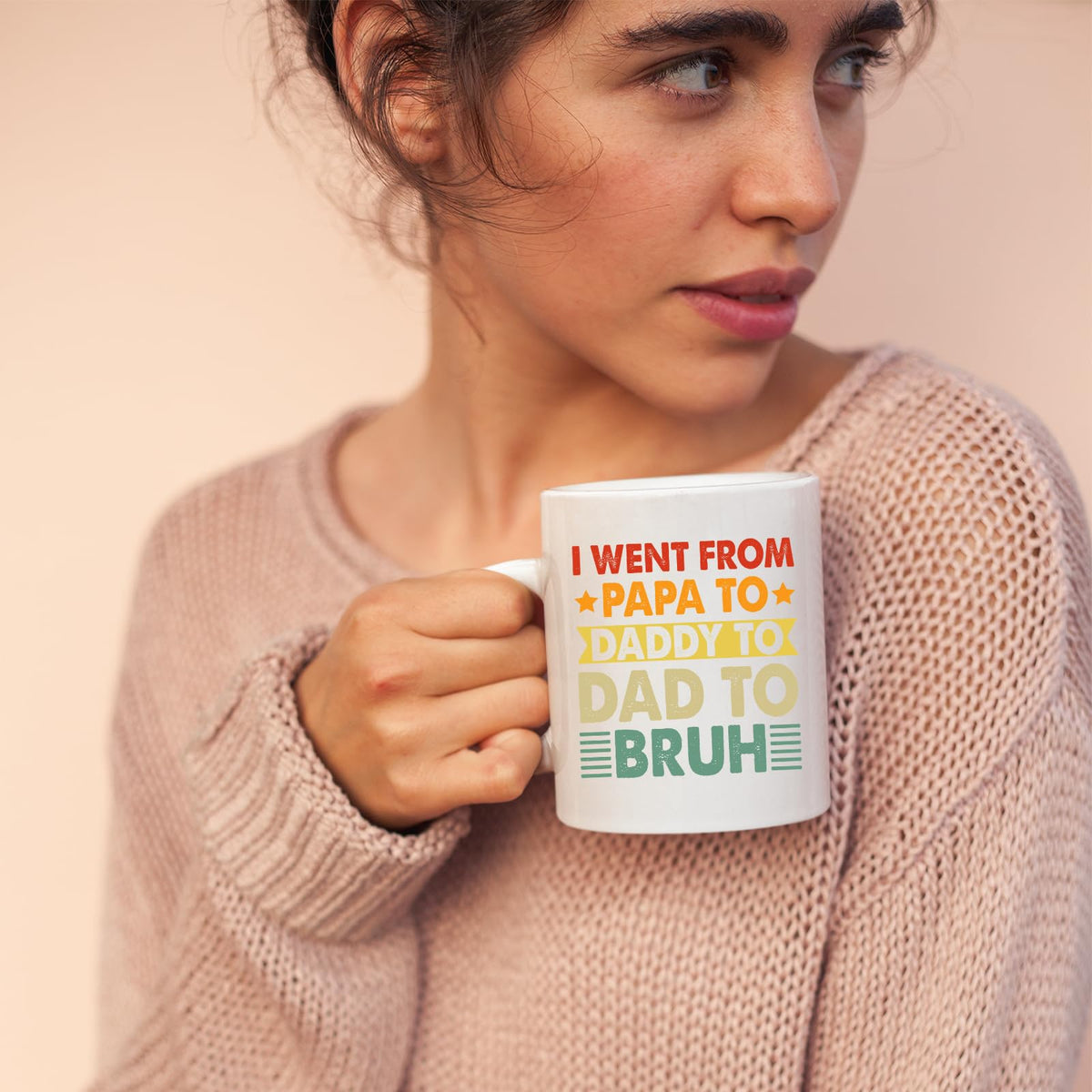 Woman in a pink jumper holding the Papa to Bruh mug