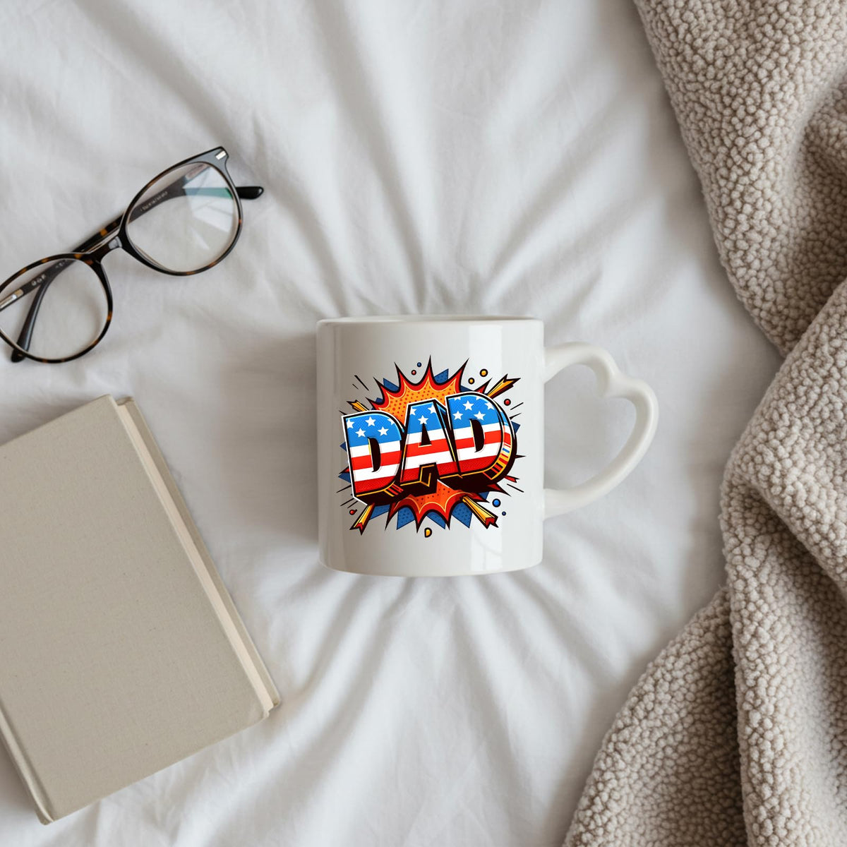 Stars and Stripes DAD heart-handle mug on a bed beside glasses and a book