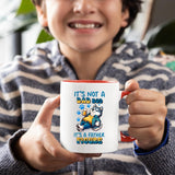 Smiling child holding the Dad Bod husky mug with a red handle