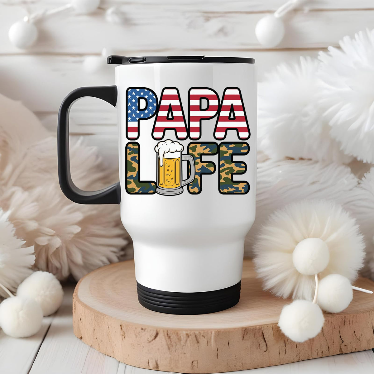 Papa Life travel mug on a wooden slice with white pom-poms