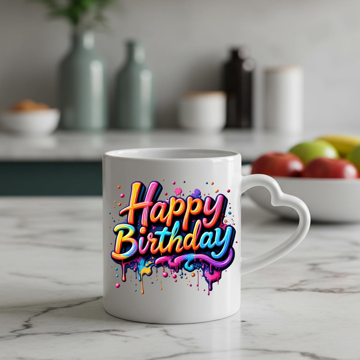 Happy Birthday rainbow drip heart-handle mug on a marble counter with fruit