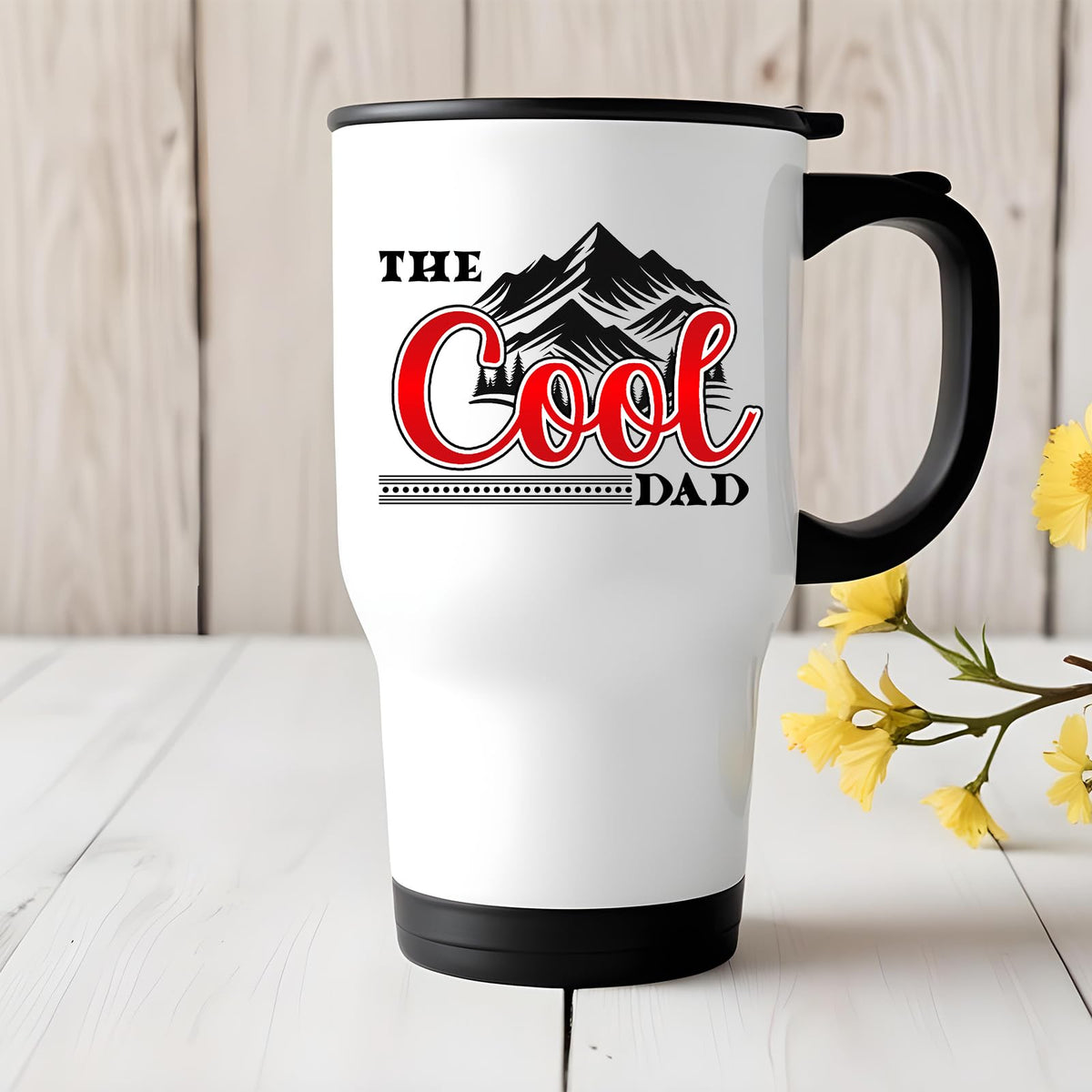 The Cool Dad mountains travel mug on a white wooden table with yellow flowers