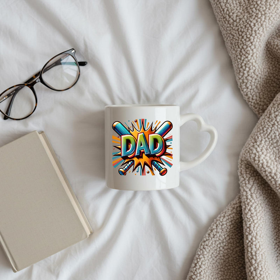 DAD baseball bats heart-handle mug on a bed beside glasses and a book
