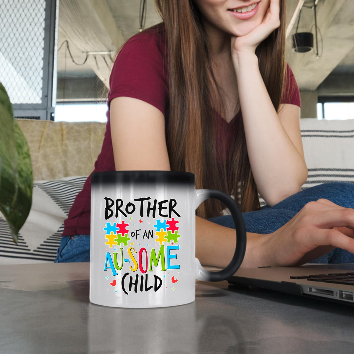Woman at a laptop with the Brother of an Au-Some Child colour changing mug