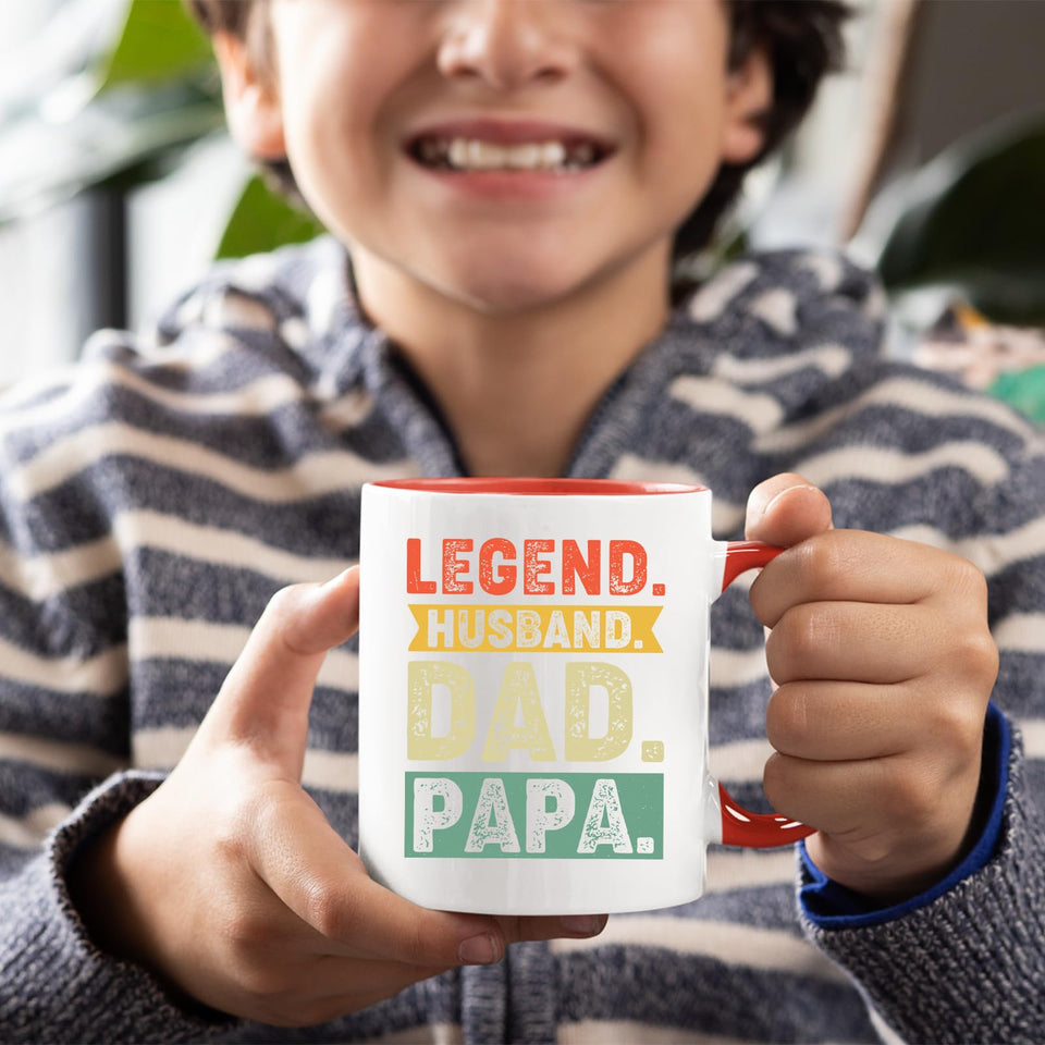 Smiling child holding the Legend Husband Dad Papa mug with a red handle