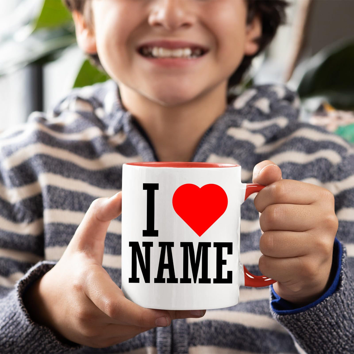 Boy holding a personalised I love name mug with a red handle
