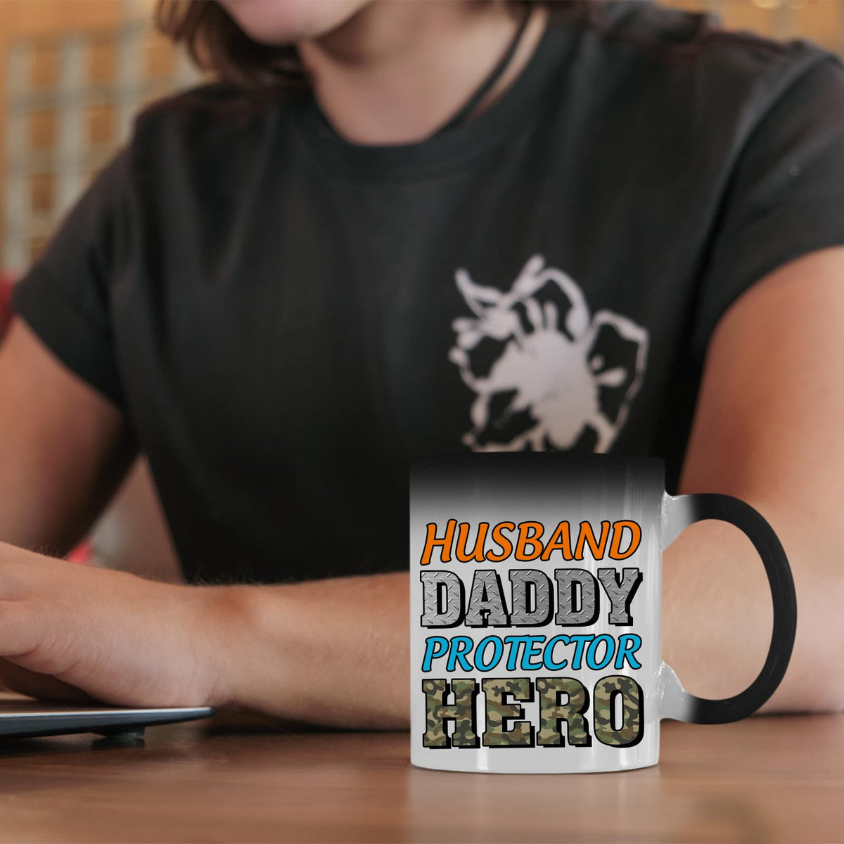 Husband Daddy Protector Hero camo colour changing mug on a desk beside a laptop